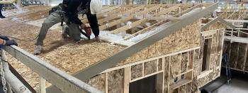 Worker constructing a manufactured home in a plant