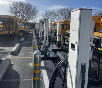 Bidirectional DC EVSE with EV Buses in the background.  