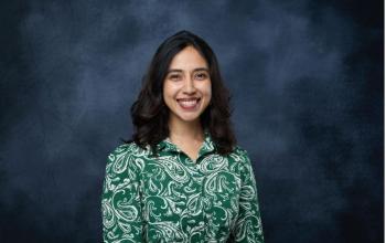 headshot of Roshni Nedungadi posed with a black backdrop in the background